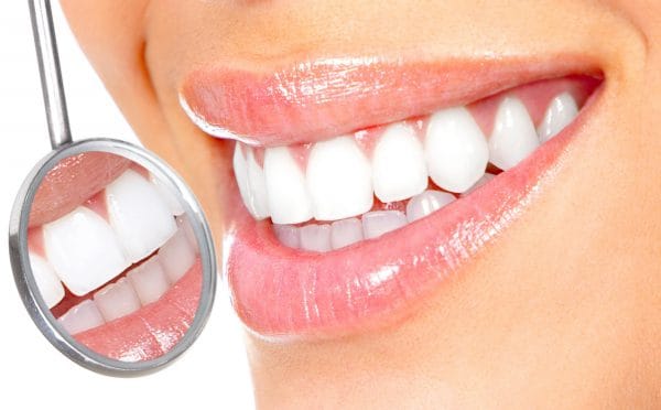 Врач-стоматолог убирает материал, не повреждая поверхность зуба и не нарушая его целостность